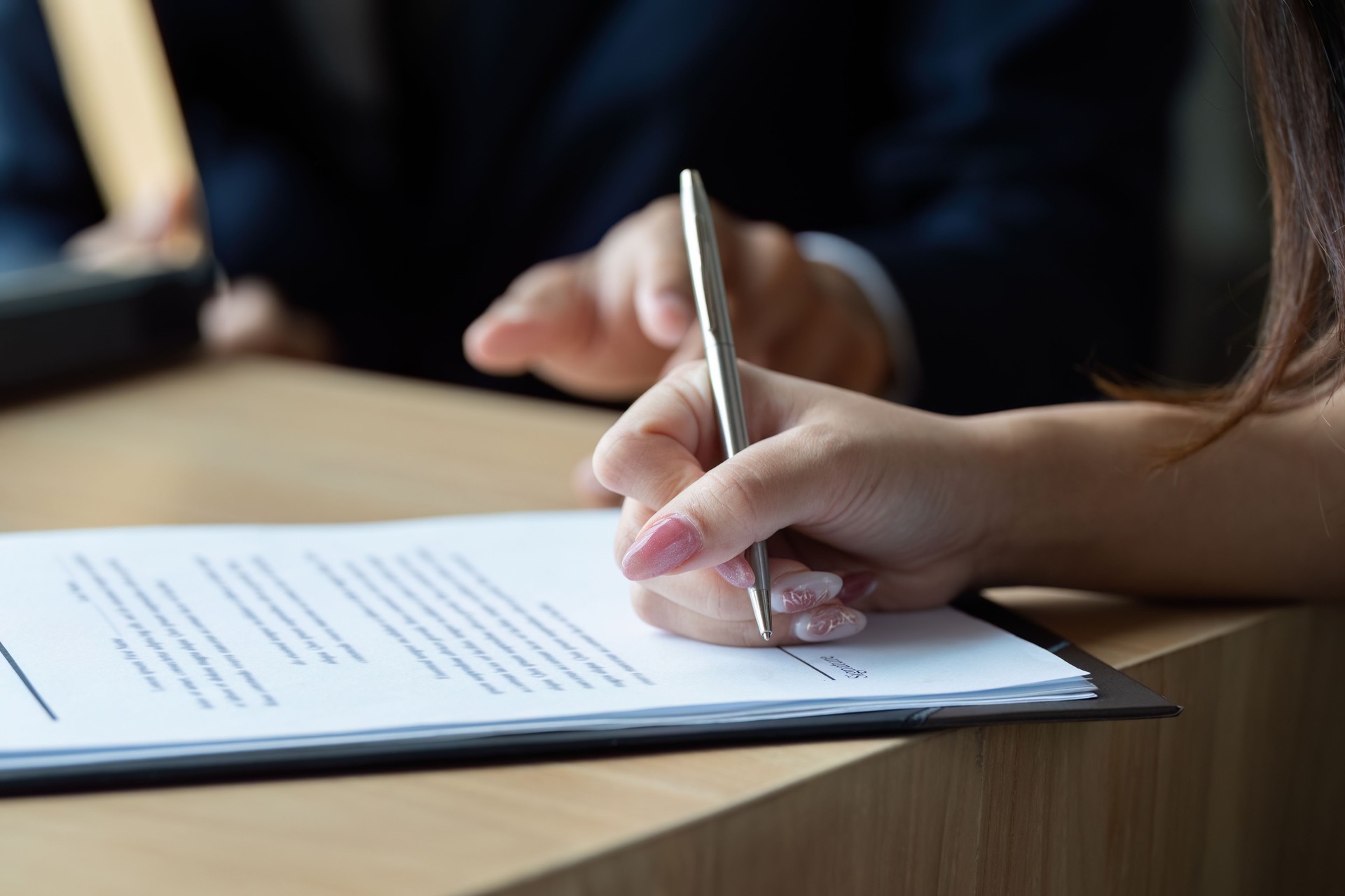 Business Agreement Signing. Professional woman signing contract with a pen.